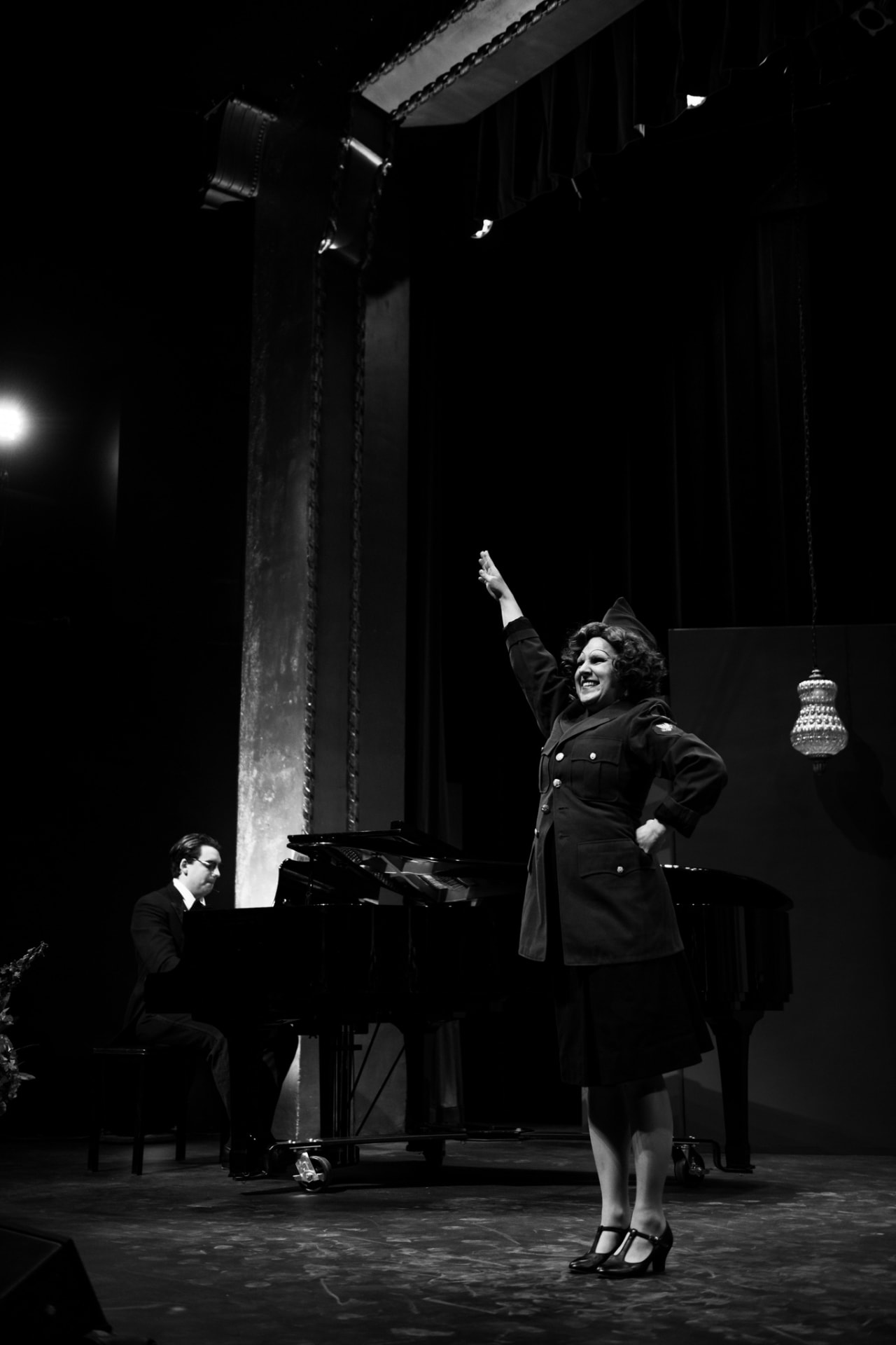 Singer in uniform beside a pianist at a grand piano