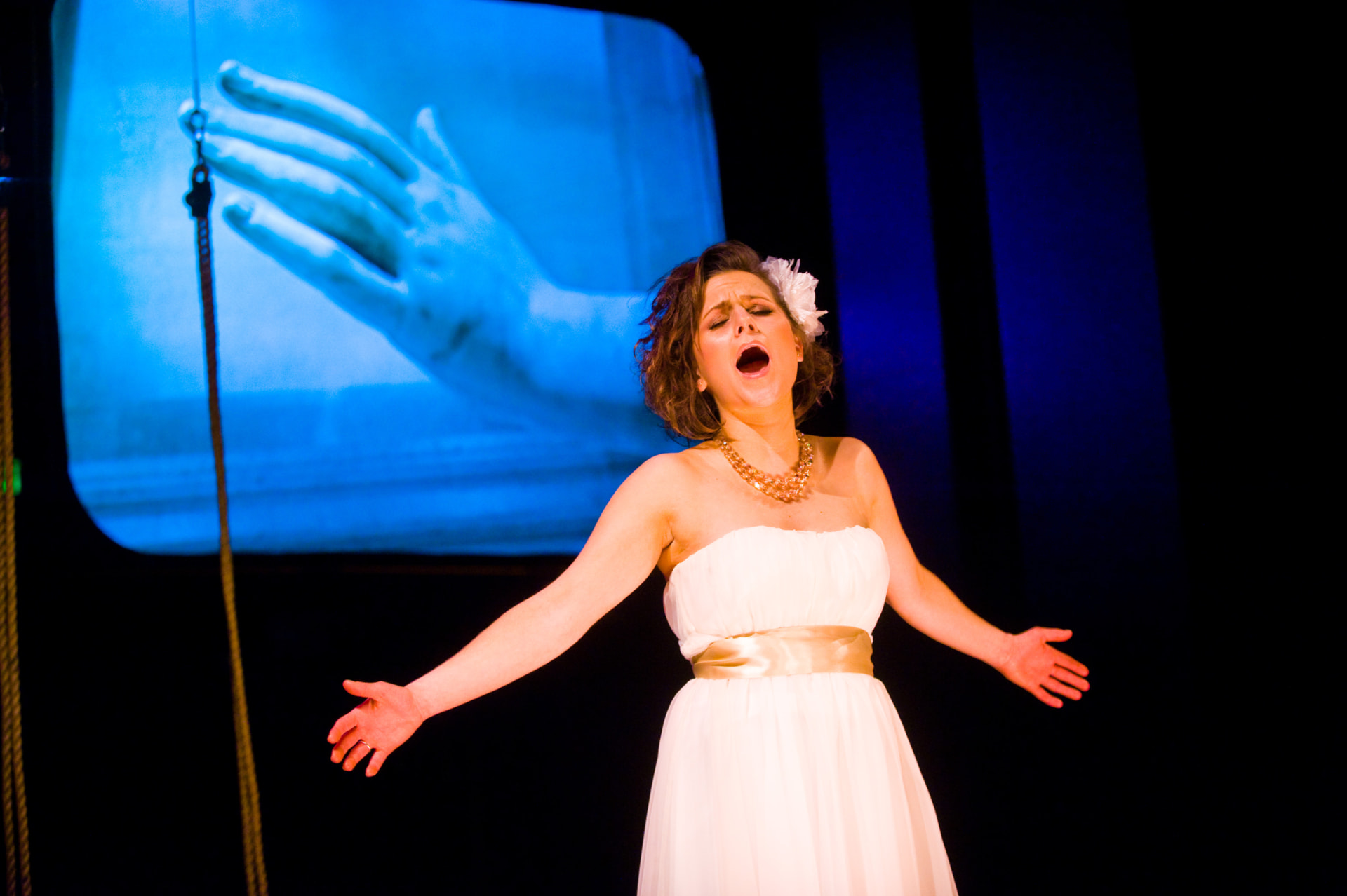 Vocal performer before a projected hand